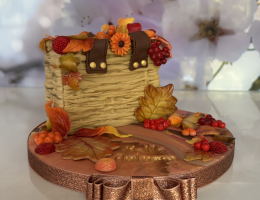 Rustic wicker bag cake with autumnal leaves, flowers and berries